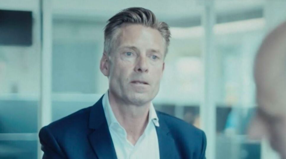Mand i mørk jakke og hvid skjorte