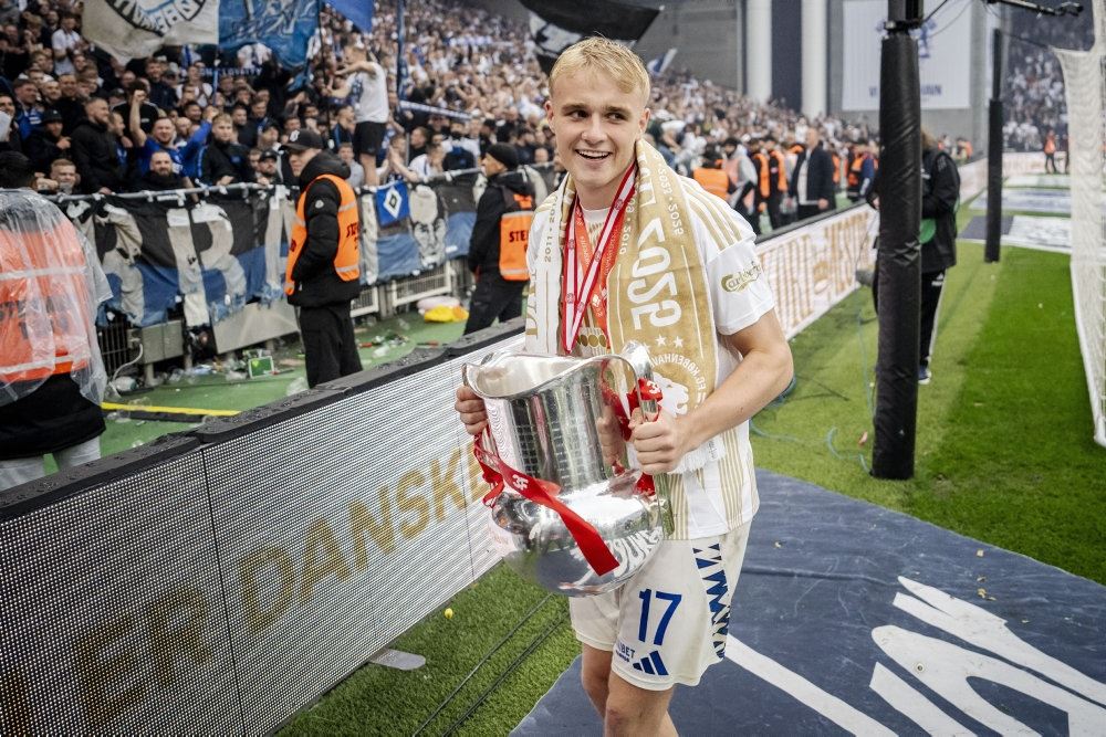 fodboldspiller står med trofæ