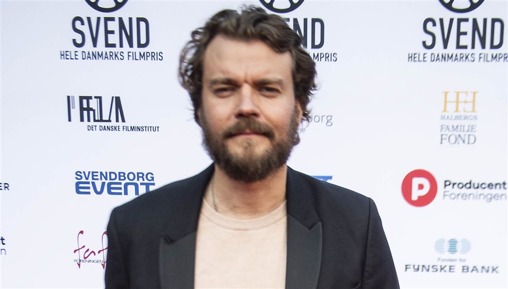 mand på rød løber med hænderne i lommen