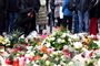 folk kigger på blomster og lys mindested