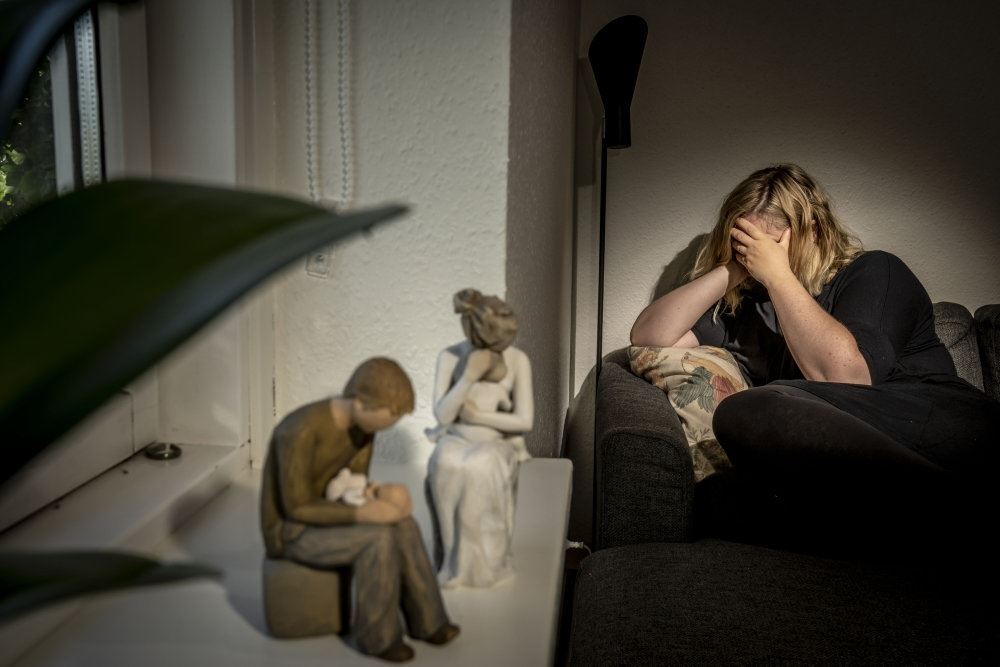 Modelfoto af ung kvinde, der tager sig til hovedet