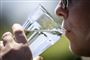 en person drikker vand af et glas