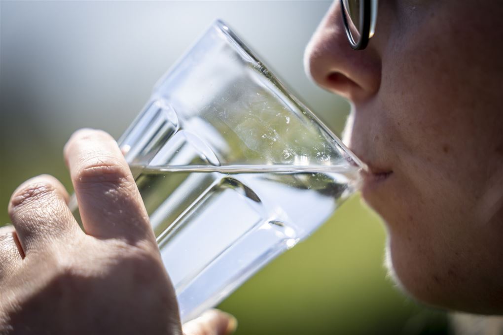 en person drikker vand af et glas